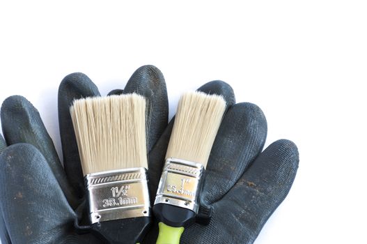 Set of brush and glove over a white background with space for text