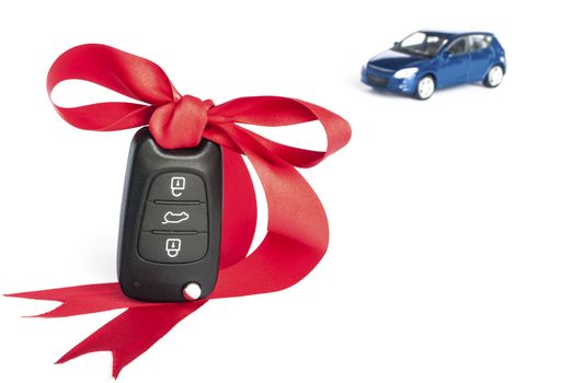 Gift car concept with red Bow and car key on focus