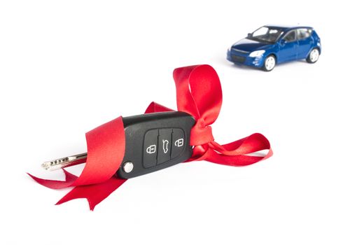 Gift car concept with red Bow and car key on focus