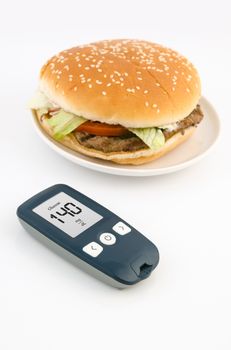 Glucometer and hamburger. Healthy lifestyle