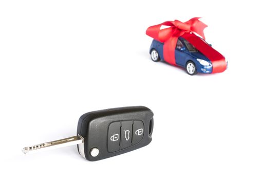 Gift car concept with red Bow and car key on focus