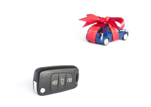 Gift car concept with red Bow and car key on focus
