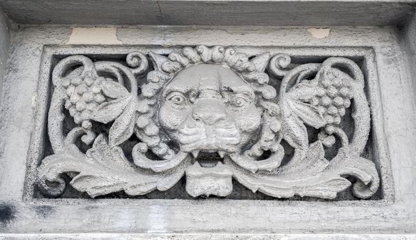 Architectural detail of a lion's head on the wall of a building