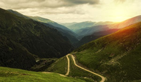 Mountain landscape with road in a summer day at the sunset.