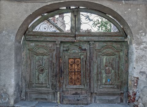 Old green wood gate on a brick wall.