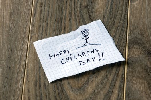 Happy Childrens Day - Kid writing with a smile man on wood background