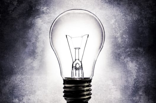 Electric light bulb on light textured background