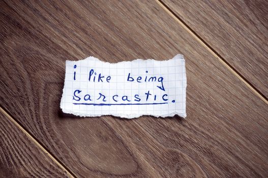 I like being sarcastic written on piece of paper, on a wood background