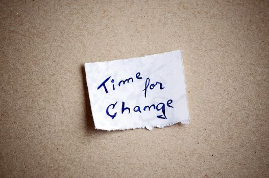 Time for change message,written on piece of paper, on cardboard background. Space for your text.