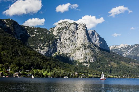 Small boat flowing on the lake in the mountains