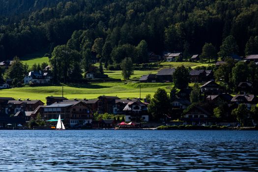 Small boat flowing on the lake in the mountains