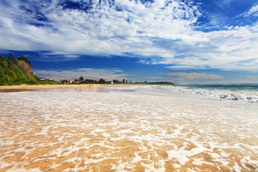 Hargraves Beach at high tide, looking north from low angle, there is motion in the receding water on the sand banks