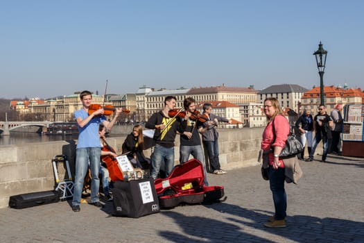 PRAGUE, CZECH REPUBLIC - MARCH 13: Charles Bridge on march 13, 2014 in Prague Czech Republic. Charles Bridge is a popular tourist attraction in Prague. On the bridge you can find many street artists.