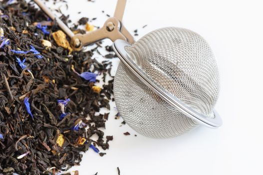 Tea ball infuser and scented tea on white background