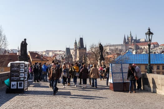 PRAGUE, CZECH REPUBLIC - MARCH 13: Charles Bridge on march 13, 2014 in Prague Czech Republic. Charles Bridge is a popular tourist attraction in Prague. On the bridge you can find many street artists.