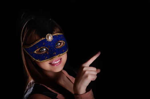 Beautiful caucasian brunette in carnival mask over blue background