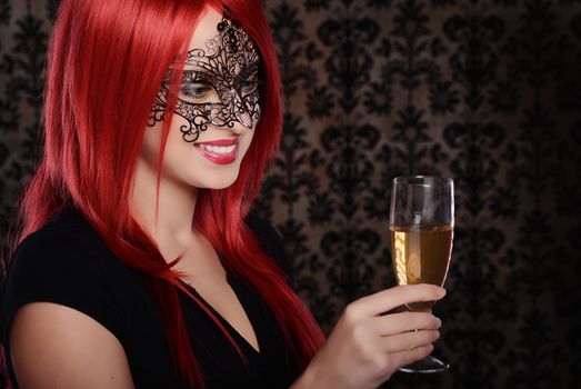 Beautiful caucasian red haired woman in carnival mask over blue background
