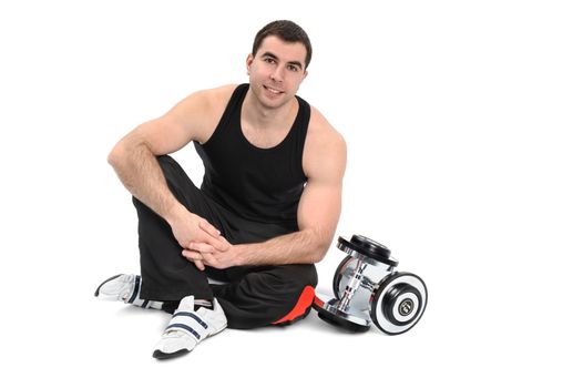 young man posing with dumbbell sitting on floor, on white background