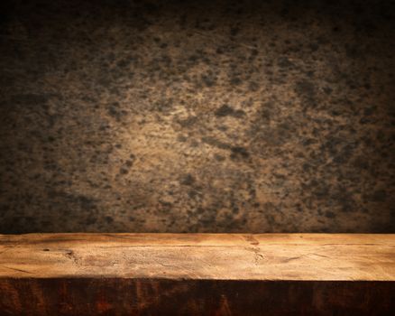Empty wooden table and dark brown wall in background