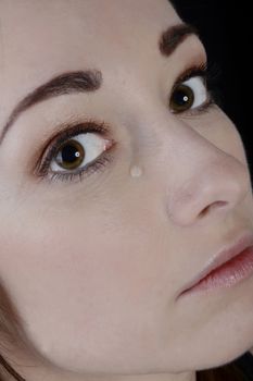 beautiful young woman crying, black background