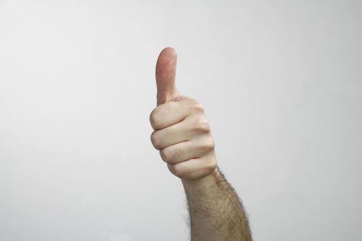 Hand with thumb up isolated on white background. Ok sign by man 