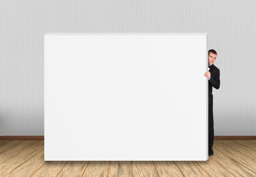 businessman looking out from behind a concrete wall