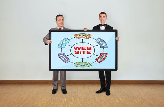 two businessman in room holding plasma panel with website scheme
