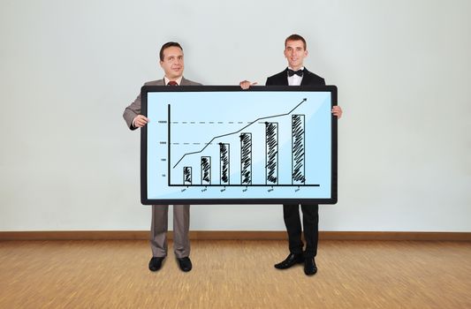 two businessman in room holding plasma panel with graph