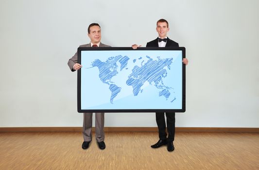 two businessman in room holding plasma panel with world map