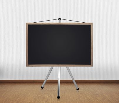 blank blackboard on tripod standing in room