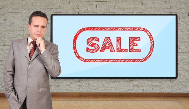 businessman thinking and big plasma with sale on wall