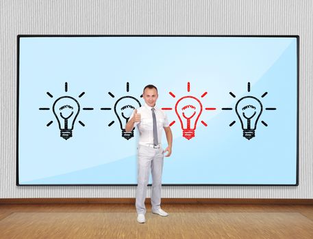 Young businessman showing thumb up and screen with lamps