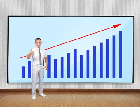 Young businessman showing thumb up and screen with chart