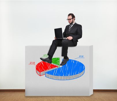 businessman sitting on concrete wall with graphic