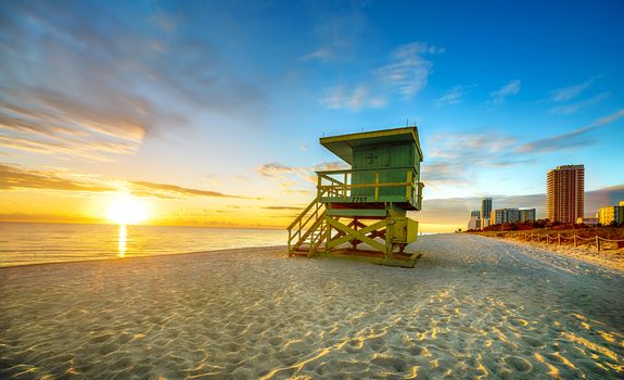 Miami South Beach sunrise with lifeguard tower and coastline with colorful cloud and blue sky. 