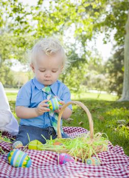 Cute Little Boy Enjoying His Easter Eggs on Picnic Blanket Outside in the Park.