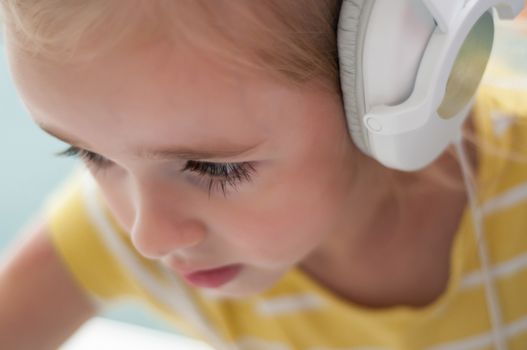 Portrait of little blond girl in headphones