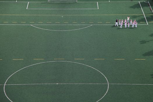 Young sports team in the field listening to their coach, Asia