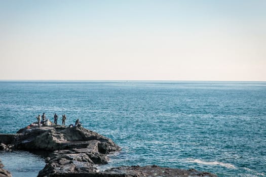 Fishing men on rocks by the japanese ocean, Asia