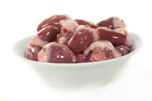 fresh raw chicken hearts against white background