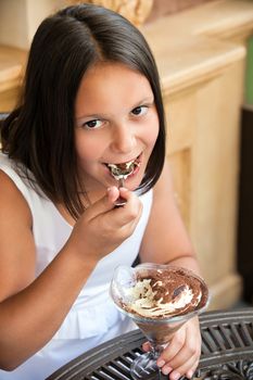 Lovely kid with ice cream in cafe