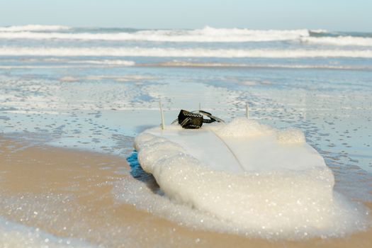 Red surfboard on the sand on a very beautiful sunny day