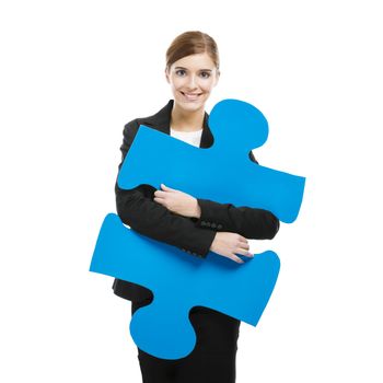 Beautiful young business woman holding a blue puzzle piece, over a white background