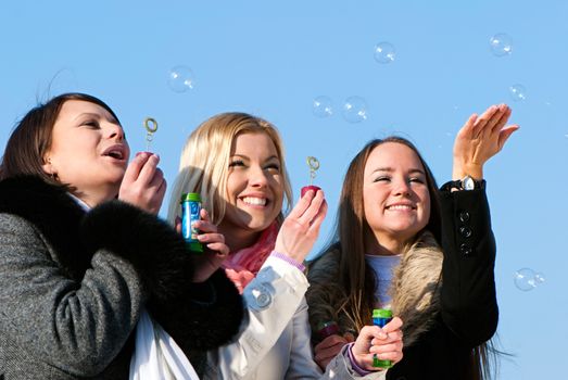 beautiful friends blowing bubbles in the nature