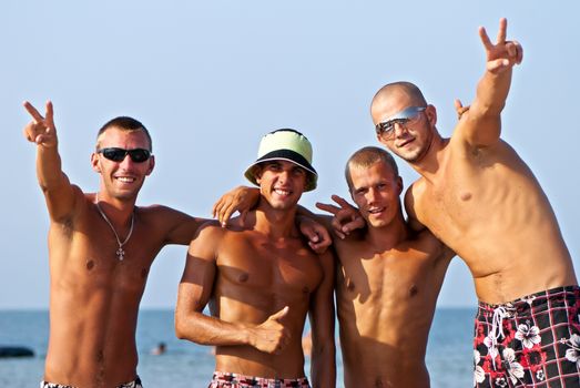 Joyful team of friends having fun at the beach 