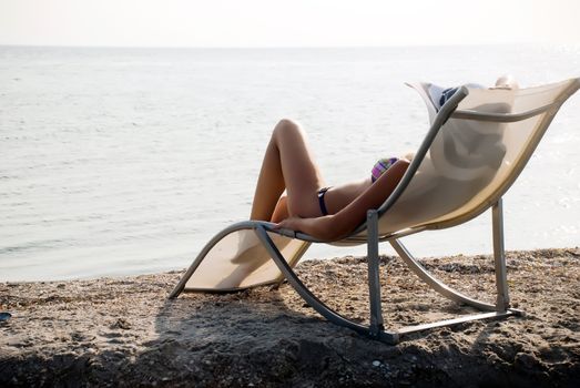 The girl in a hat having a rest on seacoast