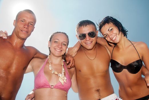 Happy group of friends smiling at the beach 