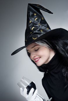 Portrait of a cute witch with hat with a Wine glass