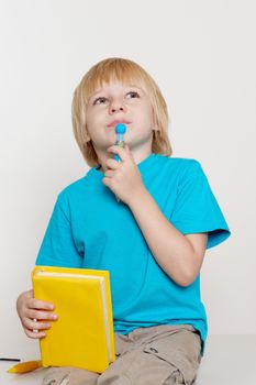 The nice boy with book and a ball pen