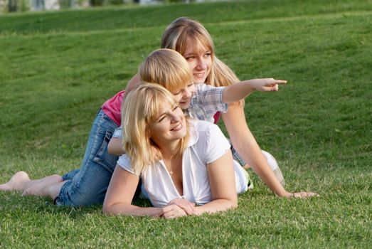 Mother with her children playing on the meadow